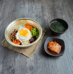 Bibimbap set serve in pot with slice dish kimchi and seaweed soup, chopstick and spoon