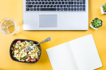 Vegetable salad with macaroni bowls with cheese in a container for lunch at the office workplace near the laptop. Top view, flat lay - Powered by Adobe