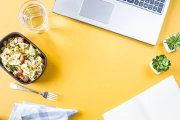 Foto op Plexiglas Groentesalade met macaroni-kommen met kaas in een container voor de lunch op de kantoorwerkplek in de buurt van de laptop. Bovenaanzicht, plat gelegd. Copyspace © svitlini