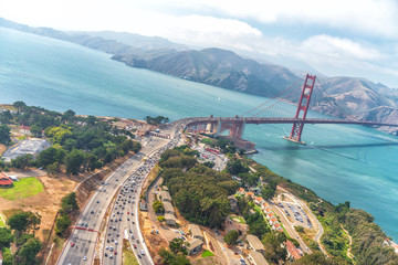 Aerial overhead view of San Francisco Golden Gate Bridge and city traffic from helicopter