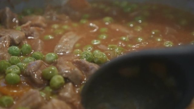 Slow motion pork meat and peas stew footage
