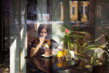 girl drinks coffee and watches video on mobile phone