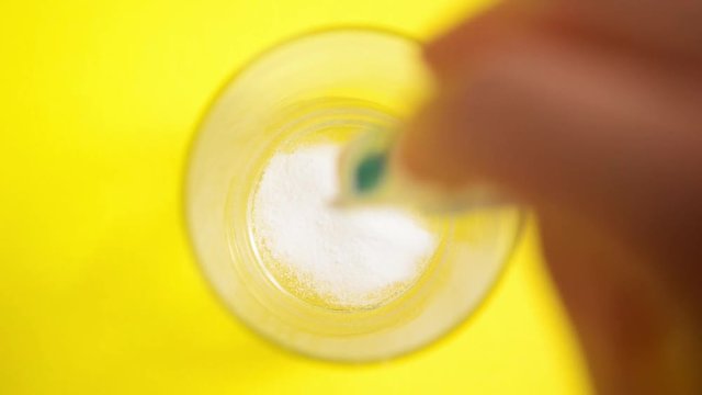 prendendo analgesico in un bicchiere di acqua