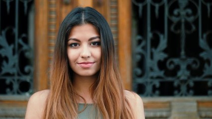 Portrait of young beautiful girl smiling outdoor. Woman with oriental face and stylish ombre dyed long haistyle. Street style. Slow motion. 4k