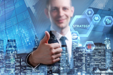 Business, Technology, Internet and network concept. Young businessman working on a virtual screen of the future and sees the inscription: Strategy
