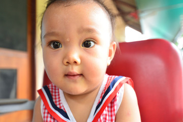 The face of an Asian baby with sweat on her face.