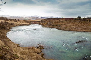 mountain river, in the distance snow mountains