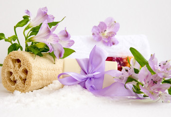 Obraz na płótnie Canvas bathroom accessories, luff, alstroemeria flower, handmade soap and white towel