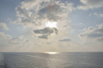 Fototapeta na wymiar Sun in the clouds at sea