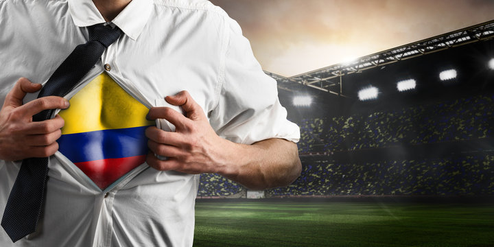 Colombia soccer or football supporter showing flag under his business shirt on stadium.