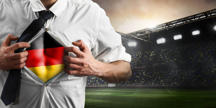 Germany soccer or football supporter showing flag under his business shirt on stadium.