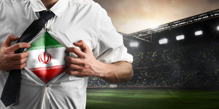 Iran soccer or football supporter showing flag under his business shirt on stadium.
