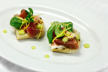 bruschetta with hamon and lime sauce and lettuce on the white plate