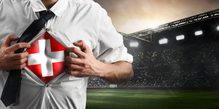Switzerland soccer or football supporter showing flag under his business shirt on stadium.