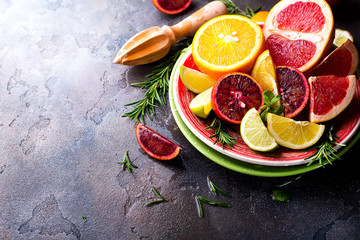 Sliced citrus fruit on the plate on stone dark background