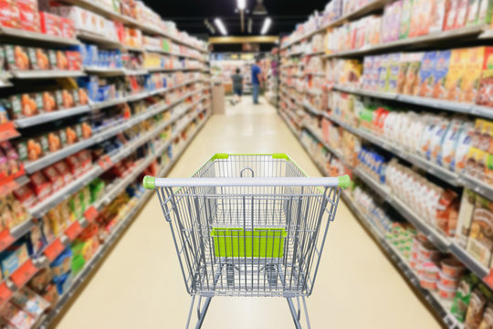 Supermarket aisle with empty shopping cart business concept