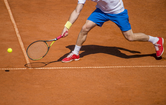 Male tennis player in action on the court on a sunny day
