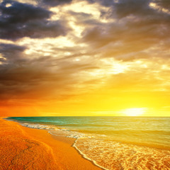 Fototapeta na wymiar dramatic sunset over a sandy sea beach