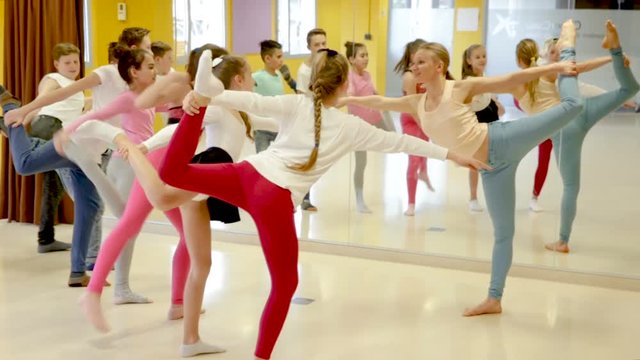 Female coach holding group dance training with teenagers in modern dance hall