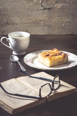 Sweet homemade apple cake and coffee. Breakfast and reading on rustic wooden table.