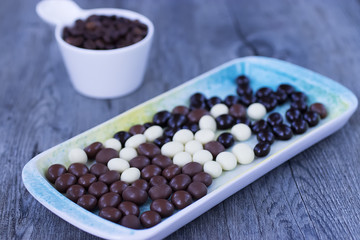 Grains of coffee in the glaze of white, milky, and dark chocolate