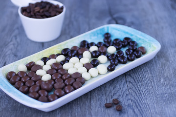 Grains of coffee in the glaze of white, milky, and dark chocolate.