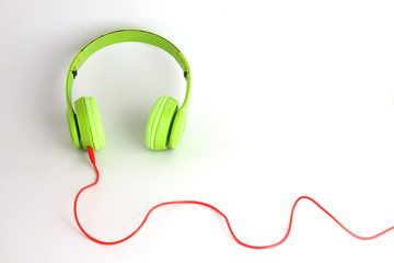 Green headphones with red acoustics. Put on white floor