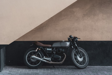 Une moto vintage appuyée contre un mur