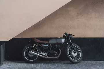 Photo sur Plexiglas Scooter Une moto vintage appuyée contre un mur