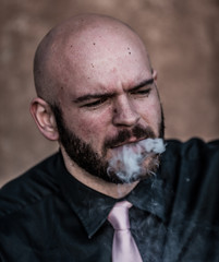 Pink Evenings by the Sea: A Caucasian Male smokes a rich cigar next to the coast. Pink accents