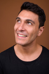 Fototapeta premium Young handsome Hispanic man against brown background