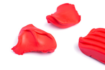 Red pieces of plasticine on a white background.