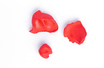 Red pieces of plasticine on a white background.