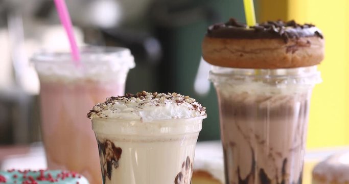 Delicious milkshakes with donuts plastic cups for takeaway in a cafe