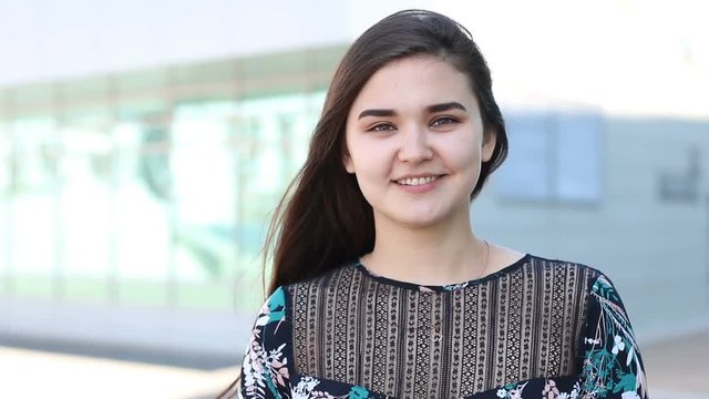Portrait of a beautiful charming smiling happy girl with beautiful smile, wind blows the hair.