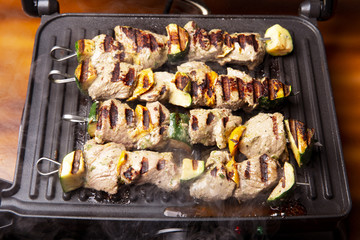 skewers of meat with vegetables on the grill.