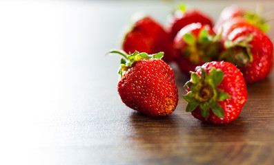 Ripe strawberries on wooden table background with copy space