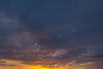 Fototapeta premium Chmury na niebie są zabarwione słońcem o świcie.