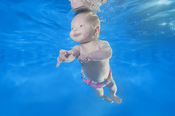 Fototapeta na wymiar 7 weeks girl swim underwater in the pool
