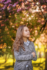 Portrait of a beautiful smiling girl with beautiful long hair in spring garden.