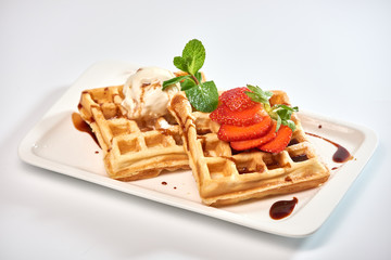Belgian waffles with strawberries./Belgian waffles with ice cream, strawberries and raspberries.
