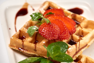 Belgian waffles with strawberries./Belgian waffles with ice cream, strawberries and raspberries.