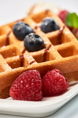 Dessert dish. Belgian waffles with ice cream, blueberries and raspberries.