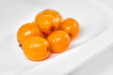 Sea buckthorn isolated on the white./Sea buckthorn on a porcelain plate. White background. Fruits of sea buckthorn.