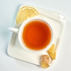 Tea with lemon and ginger./Tea in a white cup with lemon and ginger. Isolated on white background.
