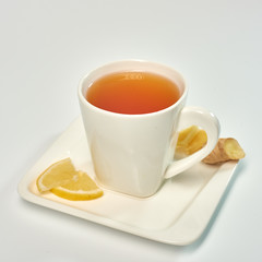 Tea with lemon and ginger./Tea in a white cup with lemon and ginger. Isolated on white background.