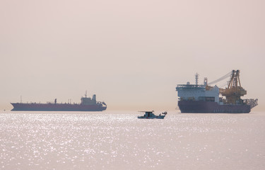 breakwater, and three ships on the horizon.