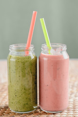 Two jars of useful smoothies with straws