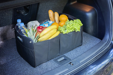 Black bag basket full of products in the car trunk
