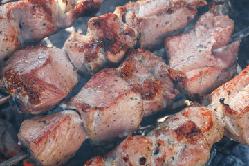 Marinate shashlyk preparing on barbecue. Close-up roasted kebab on skewer.
